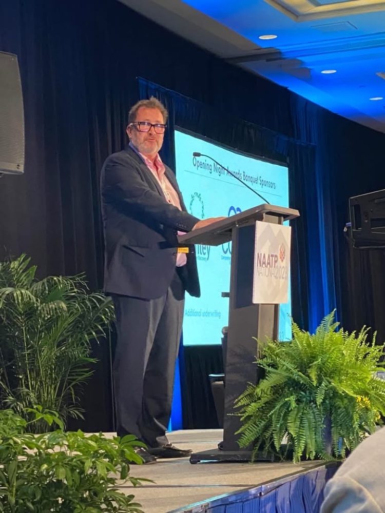 Jim Geckler speaking from a podium at the NAATP National conference